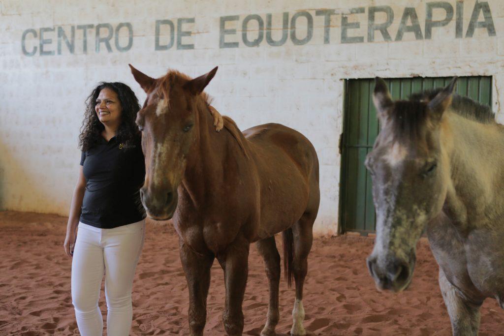Marly abraçada à cavalo à direita